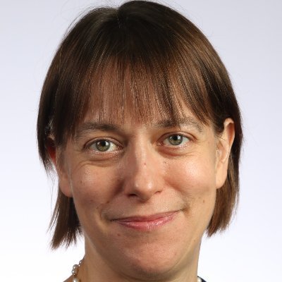 A white woman with chin-length brown hair and green eyes